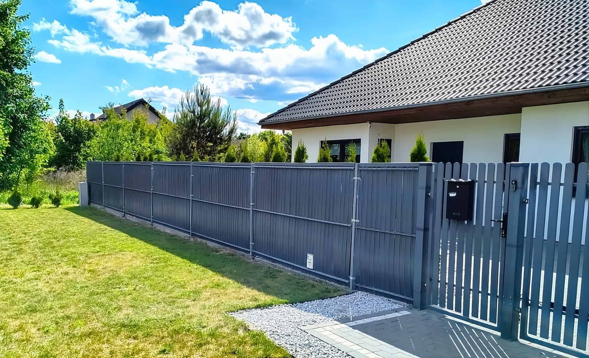 Szare listwy ogrodzeniowe przy domu jednorodzinnym